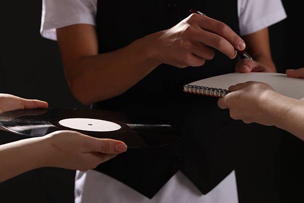 istock Singer signing autograph in notebook on black background, closeup 2235924521