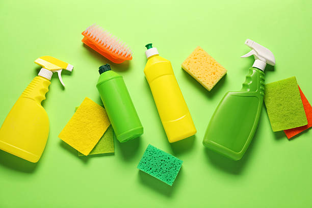 istock Cleaning products and tools on green background, flat lay 2235925532