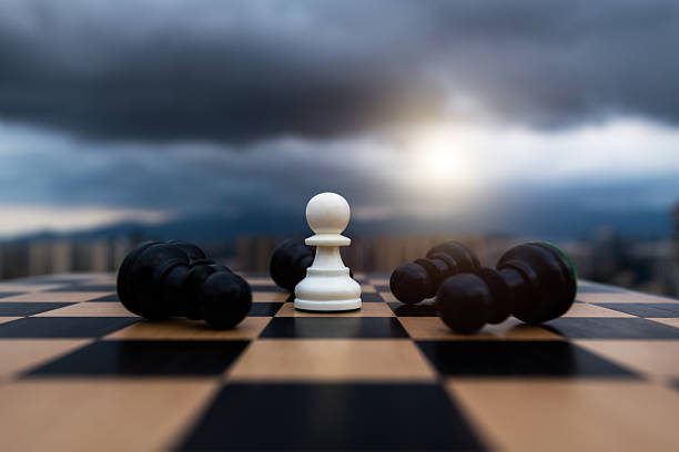 White pawn standing and black pawns lying down.
