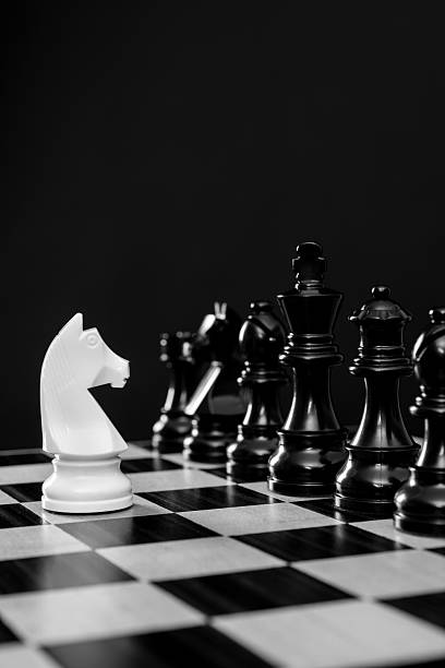 istock White knight and black chess pieces on chess board 2235926495