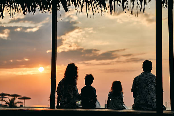 A family enjoying a tropical paradise beach during sunset.