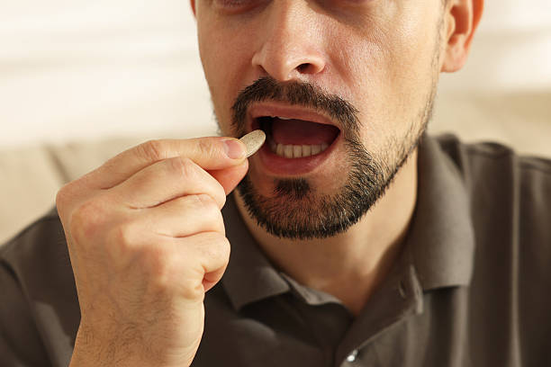 istock Man taking pill at home, closeup view 2235927174