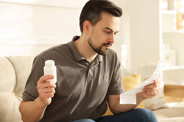 istock Man with pills reading instruction at home, selective focus 2235927200
