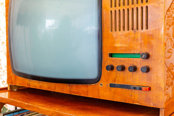 Vintage cathode-ray tube television in wooden casing, visible knobs and speaker grille, retro style, mid 20th century design.