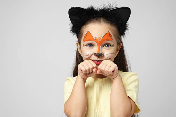 istock Cute girl with painted face and ears as cat on grey background, space for text 2235928041