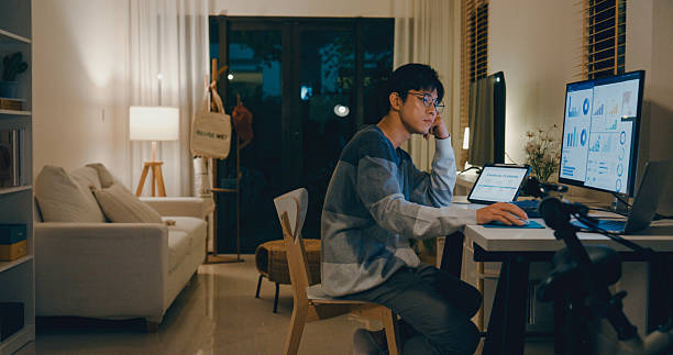 istock Young Asian man tired employee feeling mental burnout while working late at home office, overwhelmed by financial planning and data analysis tasks on multiple screens. Remotely and finance. 2235929644