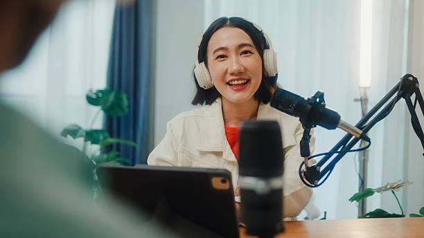 istock Generation Z podcasters collaborating wearing headphones discussing topics during recording session together in home studio. 2235930618