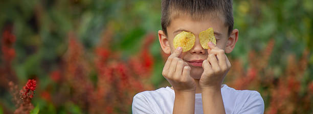 istock Boy eating chips from a pack. Unhealthy food concept 2235935221