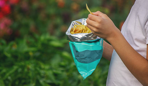istock Boy eating chips from a pack. Unhealthy food concept 2235935235
