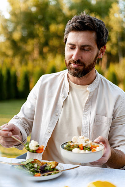 istock Handsome, middle aged man enjoying healthy vegetarian meal outdoors in a garden setting 2235935507