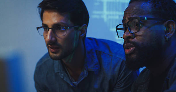 istock Closeup Black and Hispanic male engineers programmers work together collaborate discuss software development strategies in tech office late into the night. Software developer, artificial intelligence. 2235936595