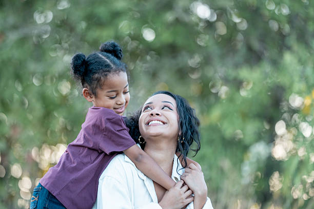 istock Smiling Mother and Daughter Hugging Each Other Outdoors on a Sunny Day 2235939227
