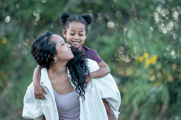 istock Mother and Daughter Smiling Outdoors in a Nature Setting 2235939794