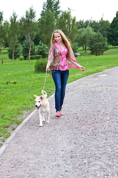 istock Girl in bright clothes playing with a cheerful dog 2235940052