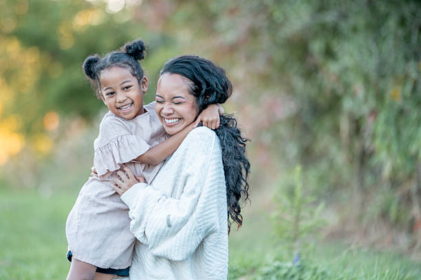 istock Smiling Mother and Daughter Embracing Outdoors in a Natural Setting 2235940579