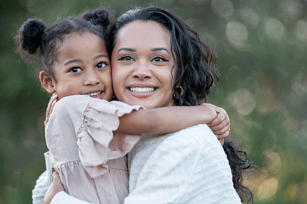 istock Loving Mother Hugging Her Smiling Daughter Outdoors on a Sunny Day 2235942640