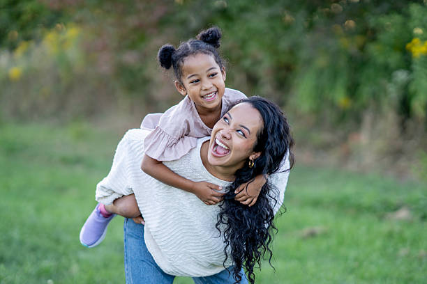 istock Mother and Daughter Smiling During Fun Playtime Outdoors in a Park 2235943111