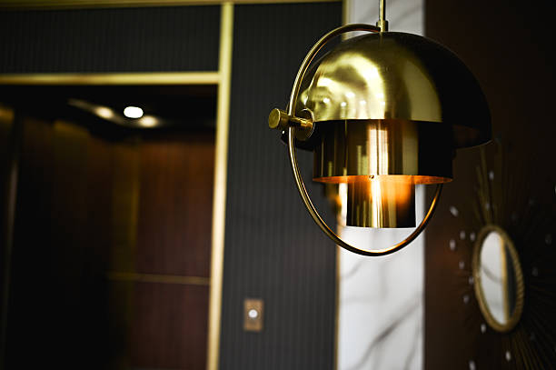istock Modern golden ceiling lamp illuminating hotel lobby with elevator in background 2235943257