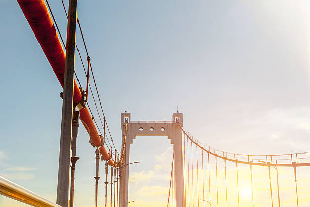 istock Sunlit suspension bridge with blue sky and cables 2235943841