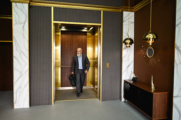 Happy young couple standing inside elevator cabin and embracing.