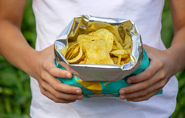 istock Boy eating chips from a pack. Unhealthy food concept 2235944856