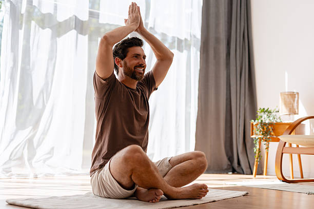 istock Man practicing yoga at home, enjoying a moment of mindfulness 2235944907