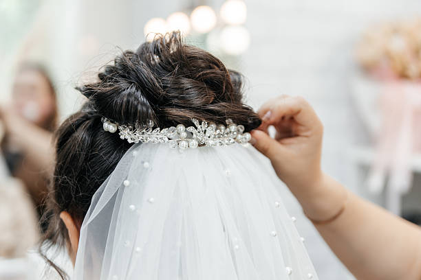 istock Woman is getting her hair done with a pearl headpiece 2235946154