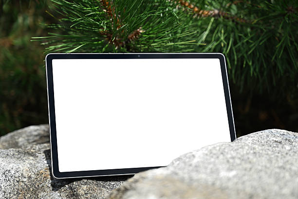 Tablet with blank white screen on rocks in nature background. Blank screen tablet for app design or presentation template.