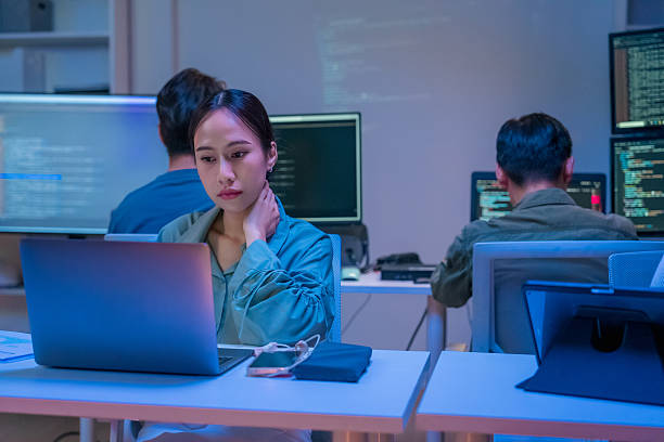 istock young Asian software development manager leads a late-night office discussion with his executive team, mentoring developers and analyzing source code to guide programming and project development 2235947855