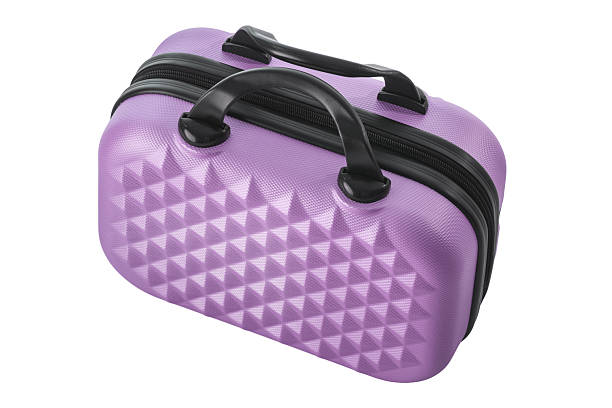 A purple suitcase on a conveyor belt, waiting to pass through an airport security scanner.