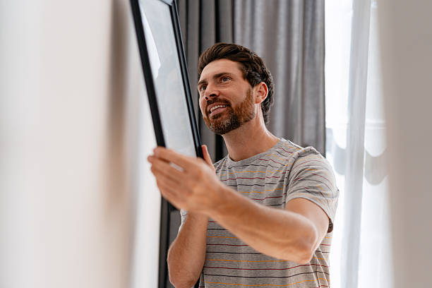 istock Man hanging a picture frame on a white wall 2235949259