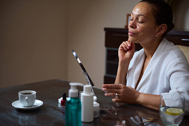 istock Woman Applying Cream While Admiring Herself in a Vanity Mirror 2235949430