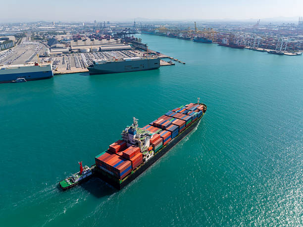 istock containers ship sailed into commercial port for load and unloading cargo from container ship for import export by crane for distributing goods by trailers transported to customers and dealers, 2235950584