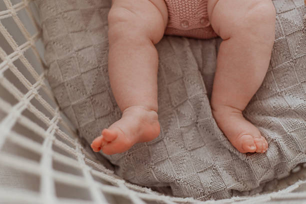 istock Baby is sitting on a blanket with its feet up 2235950969