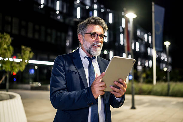 istock Businessman using digital tablet in urban environment at night 2235955305