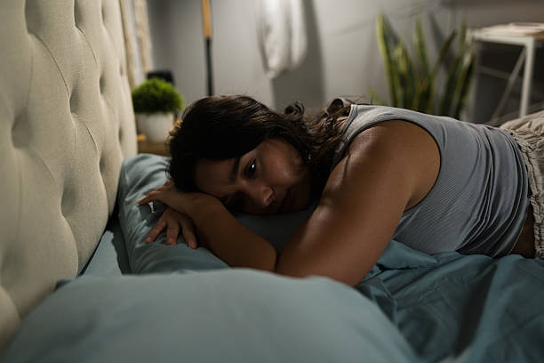 istock Latin woman feeling sad lying on bed after breakup 2235956398