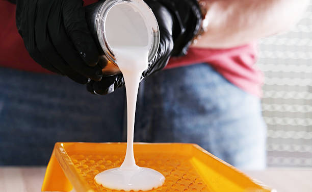 istock Repairman Pouring White Paint Into Paint Tray 2235956728