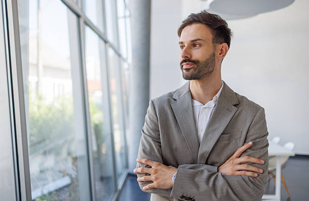 istock Pensive businessman looking out large office window 2235957308