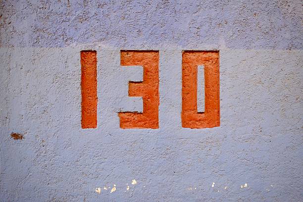 Number 16 on the facade of a baige house