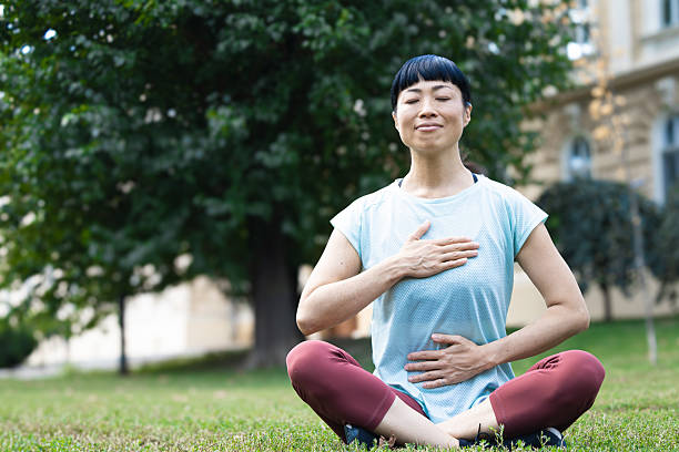 istock Mature woman practicing deep breathing exercise outdoors for wellbeing 2235957663