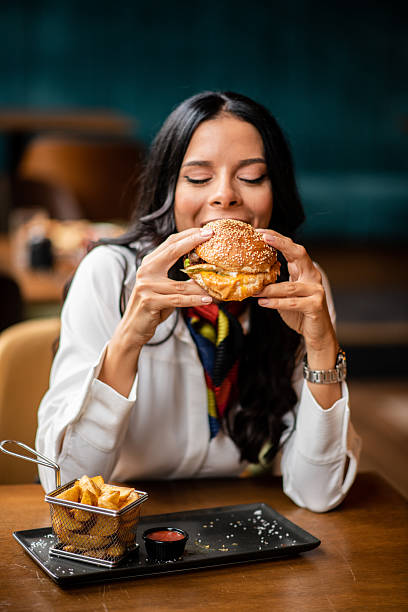 istock Woman biting juicy burger with oozing sauce 2235958299