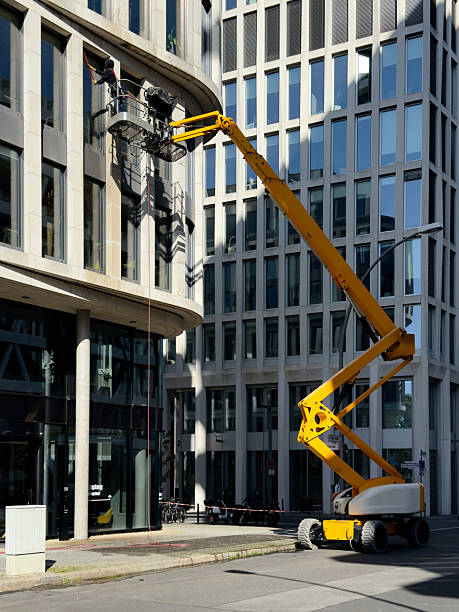 istock Cleaner worker using a cherry picker to clean a glas facade of a contemporary office building 2235959408