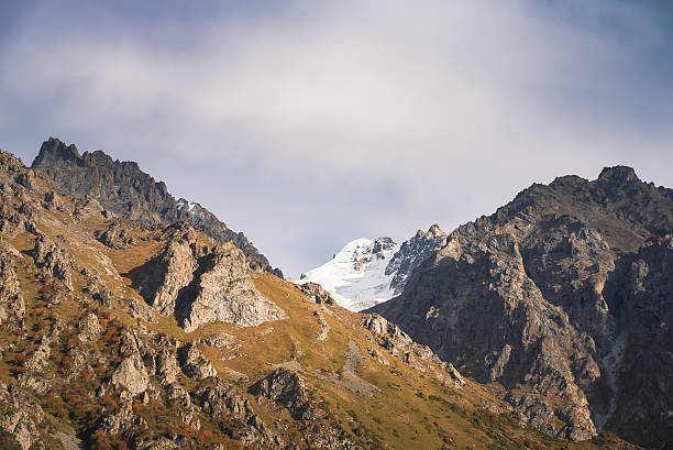 istock Stunning mountain landscape with snow-capped peak under cloudy sky 2235964586