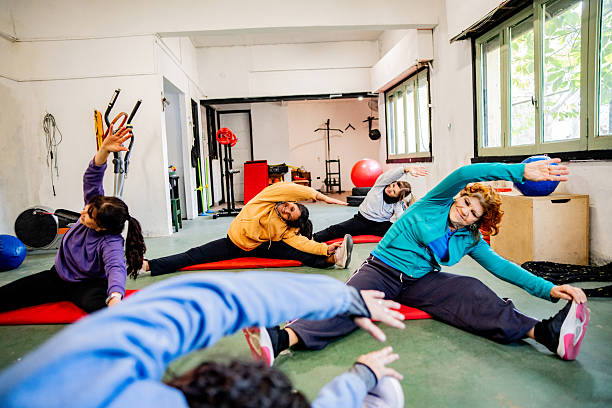 African American young girl and coach or personal trainer teaching by stretching or warm up in fitness gym. Healthy lifestyle concept