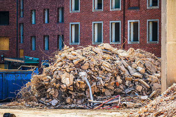 Pile of construction rubble outside brick building.