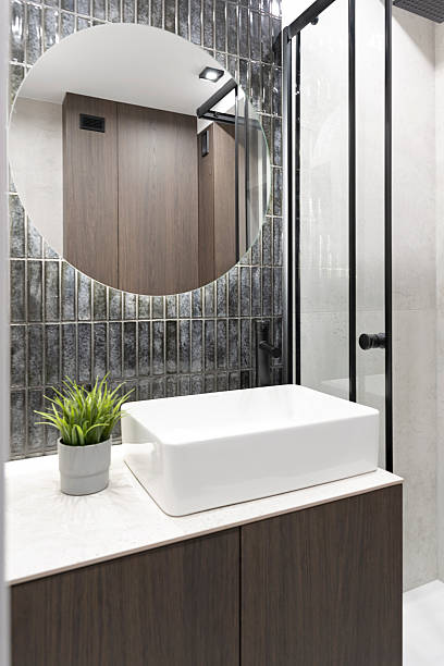 istock Modern bathroom interior with shower, white ceramic wash bowl and dark tile on the wall with mirror. New apartment with elegant design. 2235973287