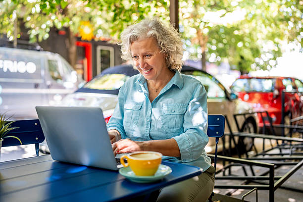 istock Mature freelancer working on laptop at outdoor cafe 2235975035
