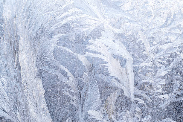 istock Captivating frost patterns on a windowpane in soft winter lighting 2235985469