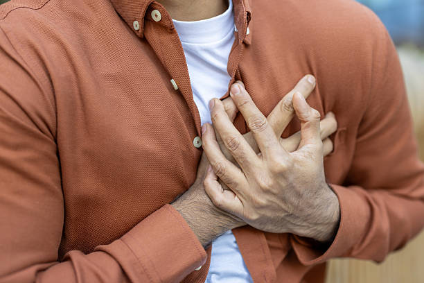 istock A man clutches his chest, indicating possible chest pain or a heart-related issue. 2235986851