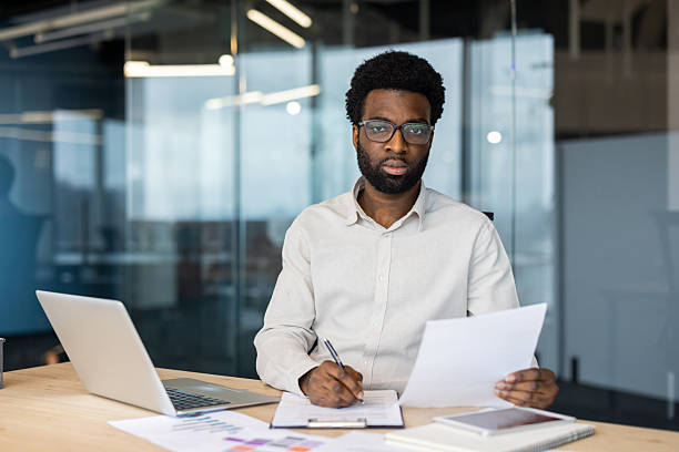 istock Professional businessman working on paperwork at a modern office desk 2235987471